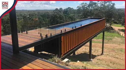Cantilevered swimming pool on a raised platform and custom deck